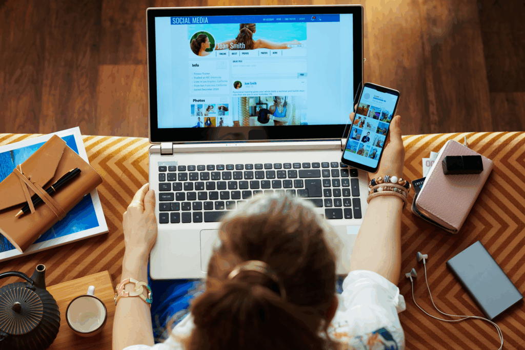 Person managing social media accounts on a laptop and smartphone, reviewing profile engagement and content visuals—illustrating modern multi-platform strategy in 2025.